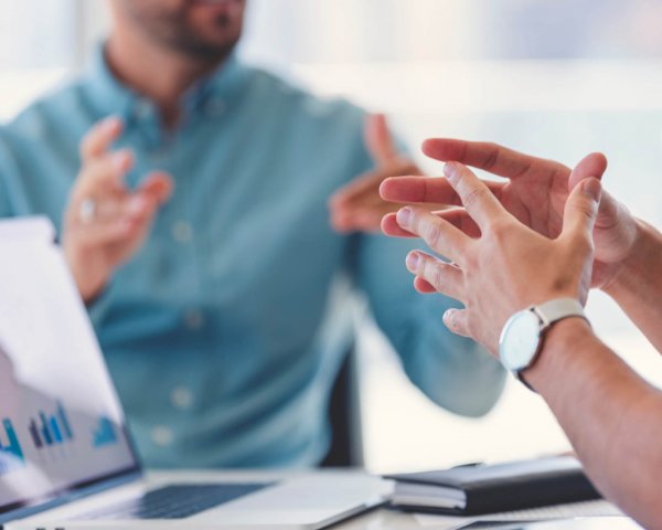 Close up of a businessman hands during a meeting. Beratungsgespräch zur Energiestrategie mit Laptop und Diagrammen