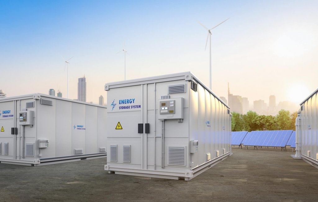 Batteriespeicher-Container mit Solaranlage und Windrädern auf einem Industriegelände